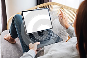 A woman using black tablet pc with blank desktop white screen as a computer pc while lying on a sofa at home