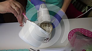 A woman using a blender prepares a marshmallow in a container. At this time, the man adds to the container syrup from the stewpan