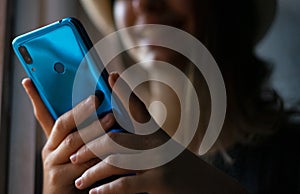 Woman using blue mobile phone at home photo