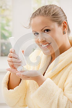 Woman using body lotion