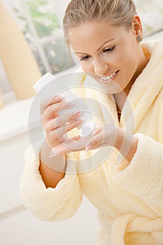 Woman using body lotion