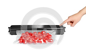 Woman using button on sealer for vacuum packing with plastic bag of cherry tomatoes on white background, closeup