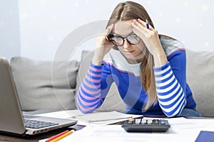 Woman using calculator for calculate domestic bills at home