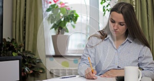 Woman using calculator for calculate domestic bills at home