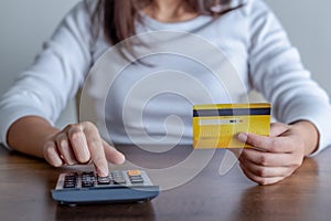 Woman using calculator how much cost or spending have with credit cards. Online payment concept