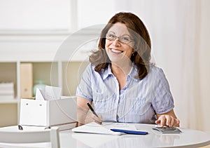 Woman using calculator to pay monthly bills