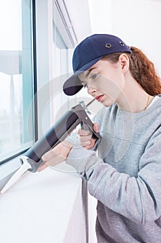 Woman using caulking gun