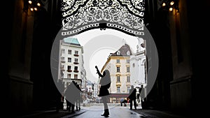 Woman using cell phone in hofburg Vienna, silhouette, wide angle