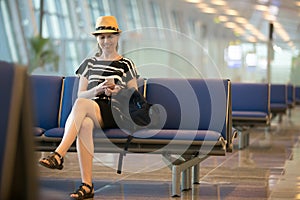 Woman using cellphone in airport waiting lounge