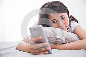 Woman using cellphone on the bed