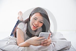 Woman using cellphone on the bed