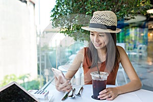 Woman using cellphone in coffee shop