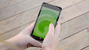 Woman using cellphone green chroma key screen wooden