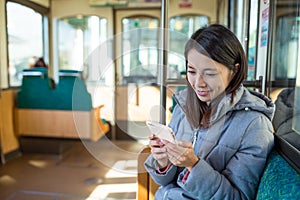 Woman using cellphone inside train compartment