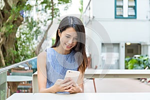 Woman using cellphone in outdoor cafe