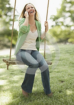 Woman Using Cellphone on a Swing