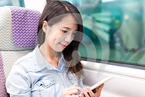 Woman using cellphone on train compartment