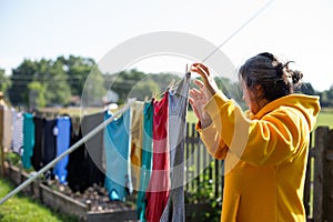 Woman Using Clothe Lines To Dry Clothes In an Energy Efficient Way