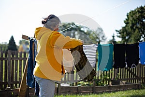 Woman Using Clothe Lines To Dry Clothes In an Energy Efficient Way