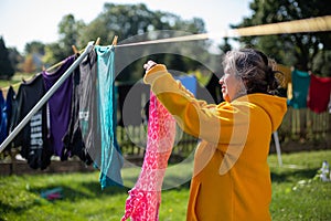 Woman Using Clothe Lines To Dry Clothes In an Energy Efficient Way