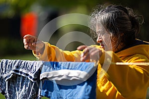 Woman Using Clothe Lines To Dry Clothes In an Energy Efficient Way photo