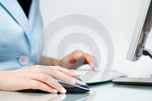 Woman using computer mouse and keyboard