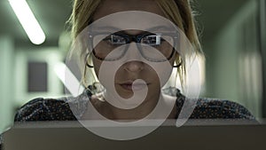 Woman using computer and computer screen light reflect from glasses