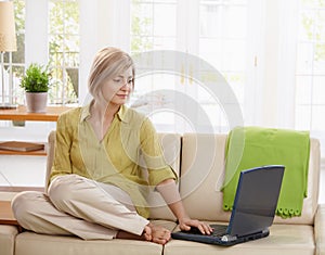 Woman using computer on couch