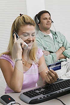 Woman Using Computer While Husband Uses iPod