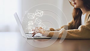 Woman using computer laptop and sending online message with email icon