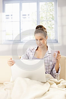 Woman using computer in morning