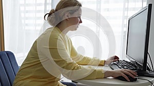 Woman using computer for online shopping, gaming, internet banking, paying bills
