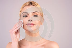 Woman using cotton pad. Beautiful girl cleaning skin by cotton pad. Facial toner or cleansing milk. Removing makeup