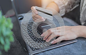 Woman using credit card filling in billing information in purchase of laptop computer in ecommerce store. Concept: online payment