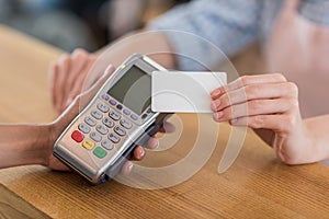 Woman using credit card for payment in cafe