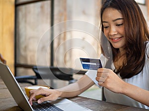Woman using credit card to shop online. shoping personal belongings through various web application applications in notebook
