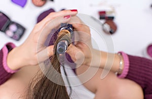 Woman using curling iron on her hair