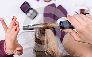 Woman using curling iron on her hair