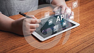 Woman using digital tablet with API application programming interface.