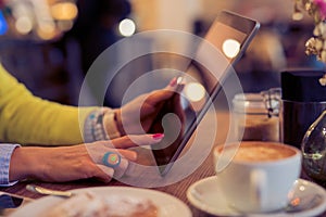 Woman using digital tablet in cafe