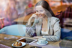 Woman using digital tablet in cafe