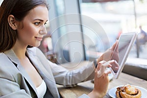 Woman using digital tablet in cafe