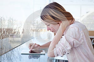 Woman using digital tablet gadget in modern interior, checking email