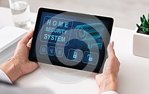 Woman using digital tablet with home security application