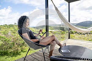 Woman using a digital tablet while relaxing sitting outdoors.