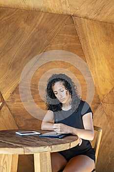 Woman using a digital tablet while sitting at a table.