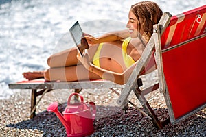 Woman using digital tablet on the sunbed