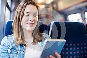 Young Woman Using Digital Tablet During Train Journey