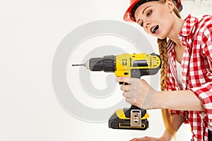 Woman using drill on ladder