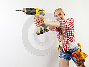 Woman using drill on wall